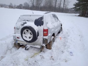 Toyota RAV4 stojąca w polach zasypana śniegiem. Widok z tyłu.