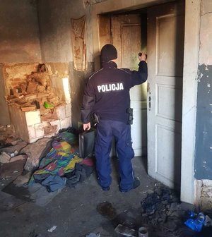 Policjant podczas sprawdzania pustostanu