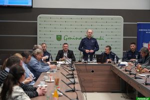 komendant komisariatu przemawiajacy na debacie, obok niego wójt i przedstawiciele Policji, przed nimi siedzacy uczestnicy debaty