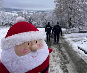 maskotka św. Mikołaja, w tle policjanci