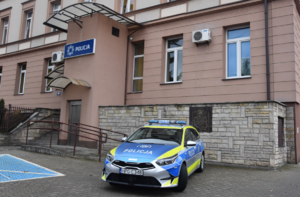 Oznakowany radiowóz stojący przed budynkiem komendy