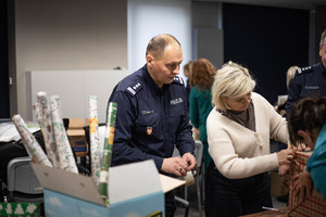 policjant pomaga zaklejać paczkę taśmą