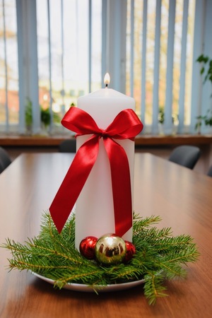 duża biała świeczka ubrana na świtęcznie z zapalonym płomieniem od harcerzy