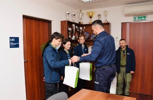 Komendant powiatowy Policji w Suchej Beskidkziej wręczający harcerzom słodkie upominki