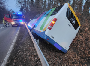 Autobus znajdujący się w rowie melioracyjnym. Na zdjęciu widoczny także wóz strażacki