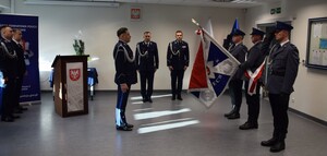 komendnat powiatowy stoi frontem do sztandaru tuż ceromonii pożegnania się ze sztandarem