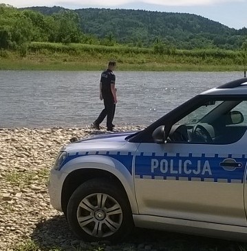 policjant stojący przy jeziorze