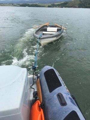 łódź wiosłowa holowana na jeziorze