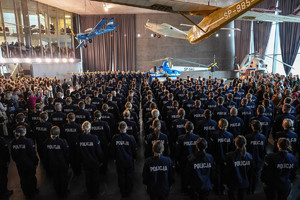 czekający na ślubowanie policjanci w rzędach zza pleców -widok na salę