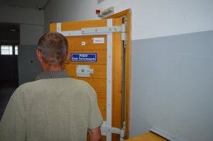 podejrzany stojący przed drzwiami do pomieszczenia dla zatrzymanych