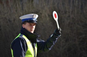 Policjant ruchu drogowego z podniesioną tarczą do zatrzymywania pojazdów