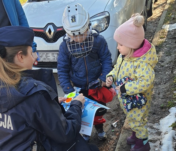 policjantka wręcza dzieciom odblaski