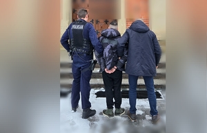 policjanci prowadzą zatrzymanego