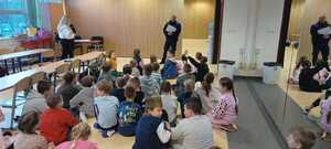 Policjanci rozmawiają z uczestnikami półkolonii