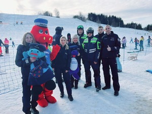 1. policjanci z maskotkami policjantów pozują do zdjęcia