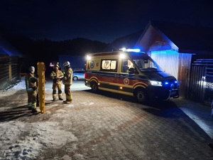 Karetka pogotowia obok której stoja strazacy2