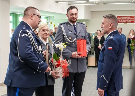 Policjanci wreczajacy prezent odchodzącemu komendantowi