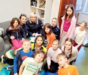 dzieci wraz z policjantkami podczas wykonywania linii papilarnych