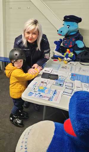 chłopiec z policjantką przy stanowisku profilaktycznym