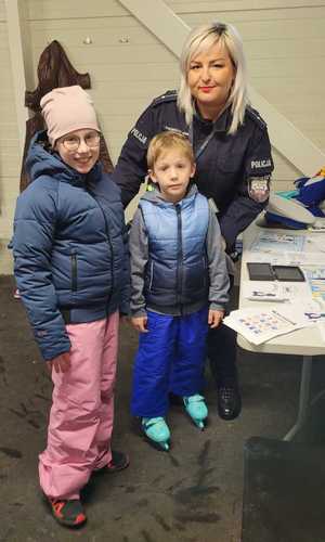 dzieci z policjantką przy stanowisku profilaktycznym
