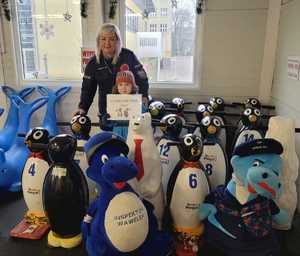 policjantka na pamiątkowej fotografi z chłopcem na lodowisku