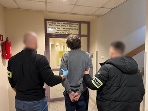 Policjanci nieumundurowani z zatrzymanym przed wydziałem