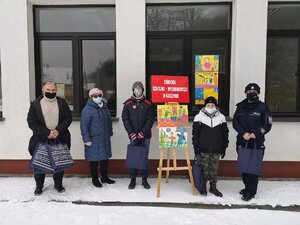 Nauczyciel, dyrektor i uczniowie z Ośrodka Szkolno-Wychowawczego w Kaczynie oraz policjant przed budynkiem placówki