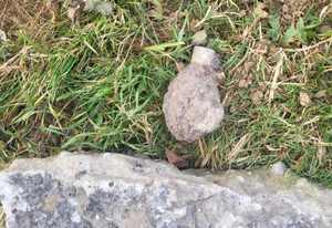 Niewybuch granatu -skorodowany leży na trawie