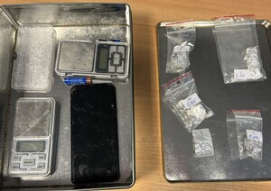 na stoliku w metalowym opakowaniu poukładane foliowe woreczki z zawartościa narkotyków oraz dwie wagi elektroniczne.