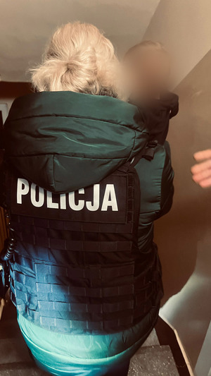 policyjna negocjatoraka z dzieckiem na rękach na klatce schodowej