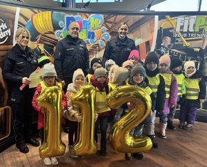 policjanci z dziećmi na terenie Parku Wodnego. Dzieci trzymają napis 112