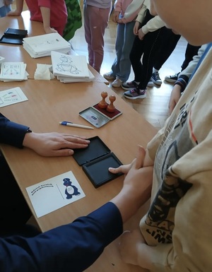 Uczniowie wykonujący odbitki linii papilarnych.