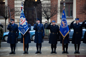 Policjanci stojący na komende na prawo patrz