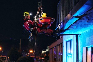 ratownik na linie ściągający ludzi z balkony
