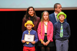 dzieci w kolorowych kapeluszach wraz z nauczycielami na scenie