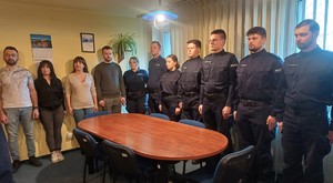 uczestnicy uroczystego wprowadzenia zastępcy komendanta stojący wokół stołu