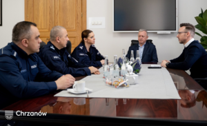 umundurowani policjanci rozmawiają przy stole z z Burmistrzem Chrzanowa