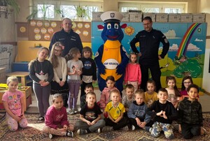 policjanci wraz z grupą dzieci oraz maskotką Komendy Miejskiej Policji w Krakowie