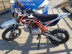 Motocykl typu cross na tle radiowozu