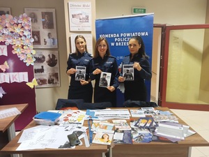 policjantki trzymające w rękach ulotki dotyczące przyjęcia do slużby w policji