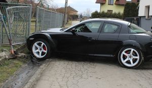 Mazda przy uszkodzonym ogrodzeniu