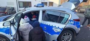 dzieci oglądają policyjny radiowóz przed komisariatem