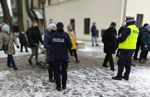 Policjantka wydziału prewencji oraz policjant ruchu drogowego rozdają odblaski osobom, które wyszły z kościoła.