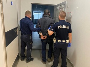 Zatrzymany mężczyzna w asyście dwóch policjantów