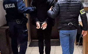 Zatrzymany mężczyzna w kajdankach obok policjant prewencji i wydziału kryminalnego