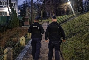 dwóch umundurowanych policjantów w trakcie patrolowania jednej z ulic miasta