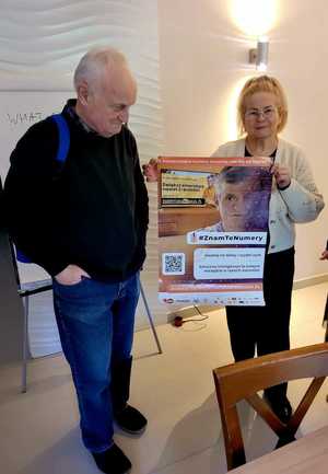 seniorzy prezentuja plakat informacyjny