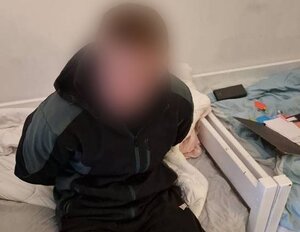 zatrzymany oszust siedzący na łózku