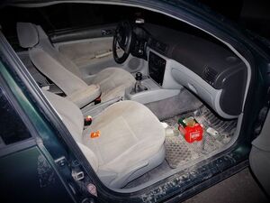 wnętrze uszkodzonego pojazdu z piwem i wódką na podłodze