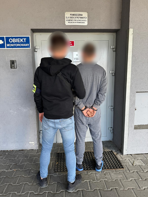 Nieumundurowany policjant trzyma zatrzymanego męzczyznę